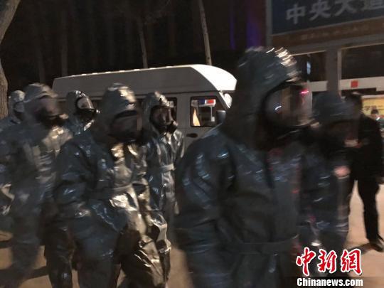 十几名身着防护服的人员头戴面具进入事发地。　胡健 摄